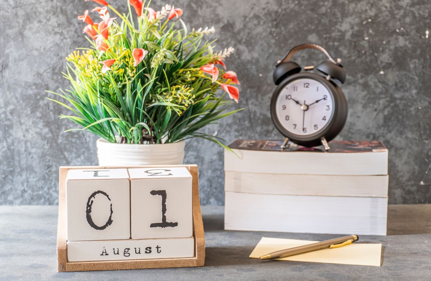 A desktop calendar and clock arranged on a table, evoking the passage of study time.