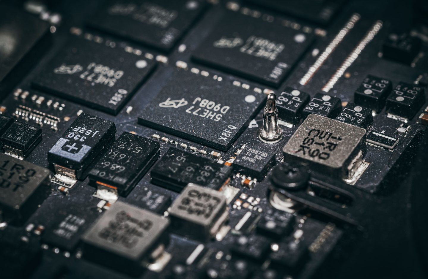 Close-up macro photo of electronic microchips and components on a circuit board.