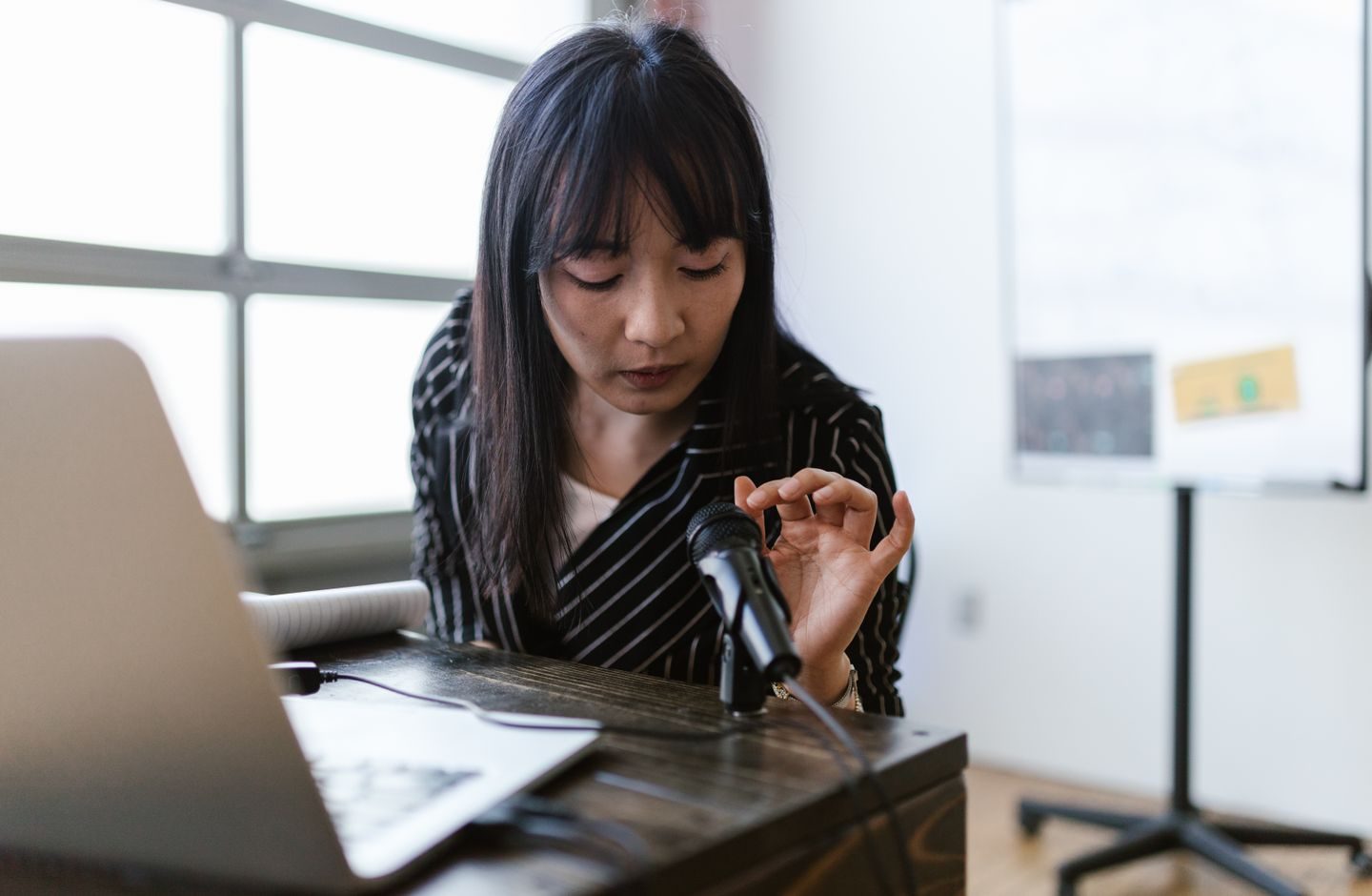 A woman speaking into a microphone, practicing pronunciation out loud.