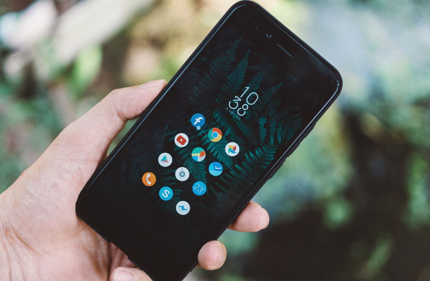 A person holding a smartphone displaying an app screen.