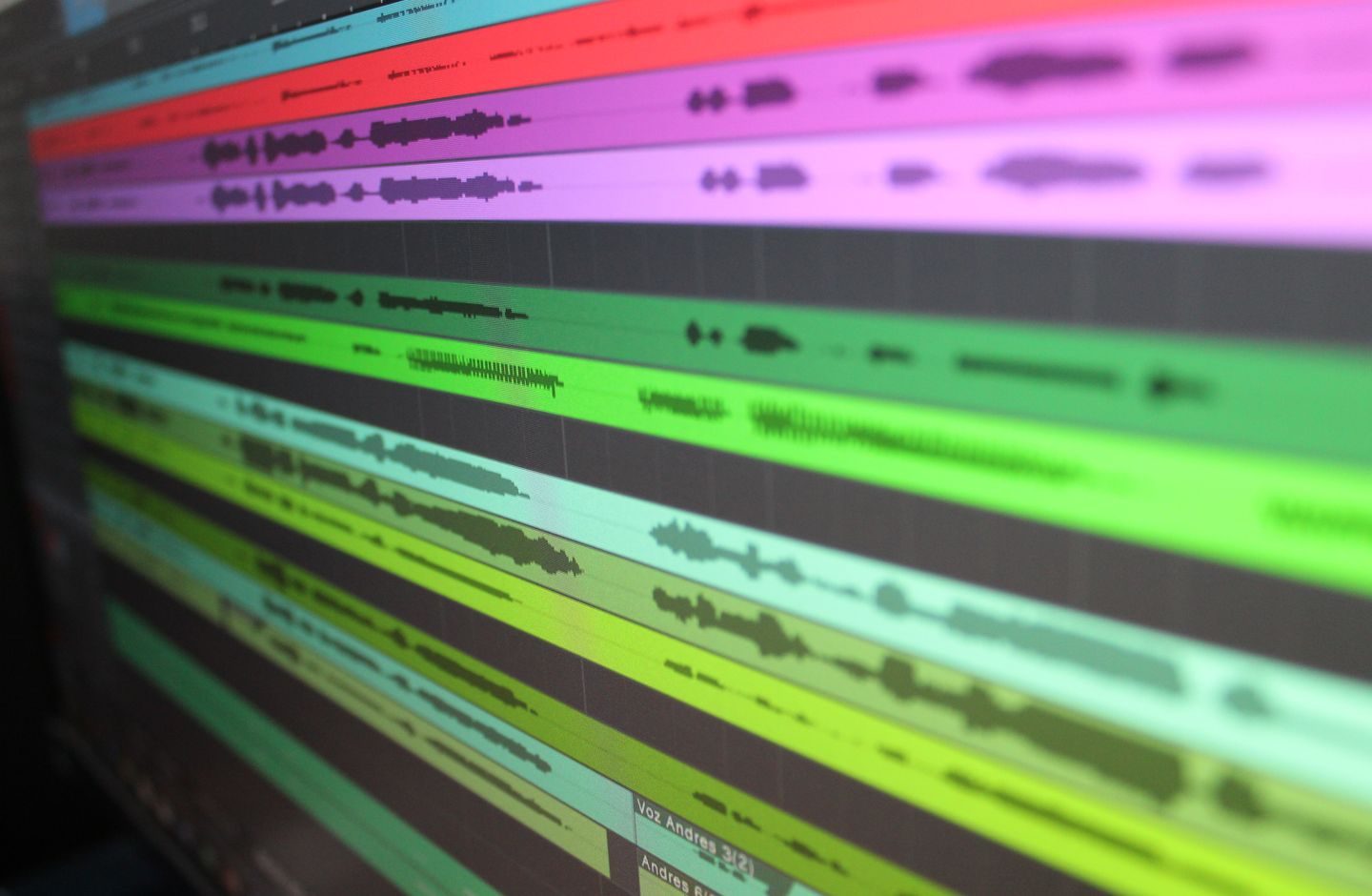 Colorful audio waveforms on a screen, each track showing a different pitch pattern.
