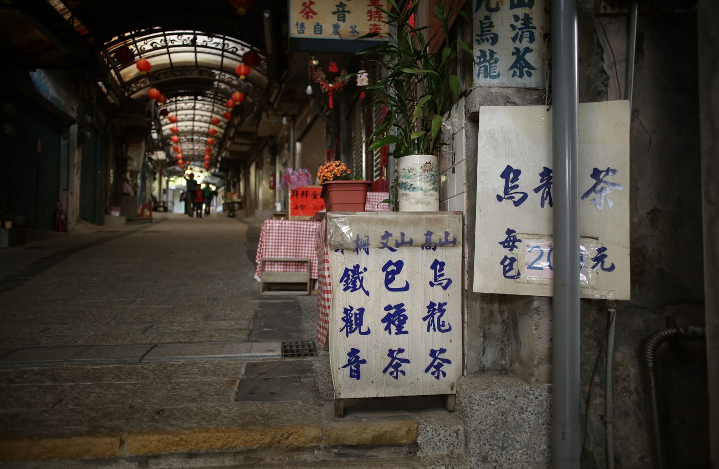 A tea shop's hand-painted sign in Traditional Chinese characters, in a covered market alley in Taiwan.