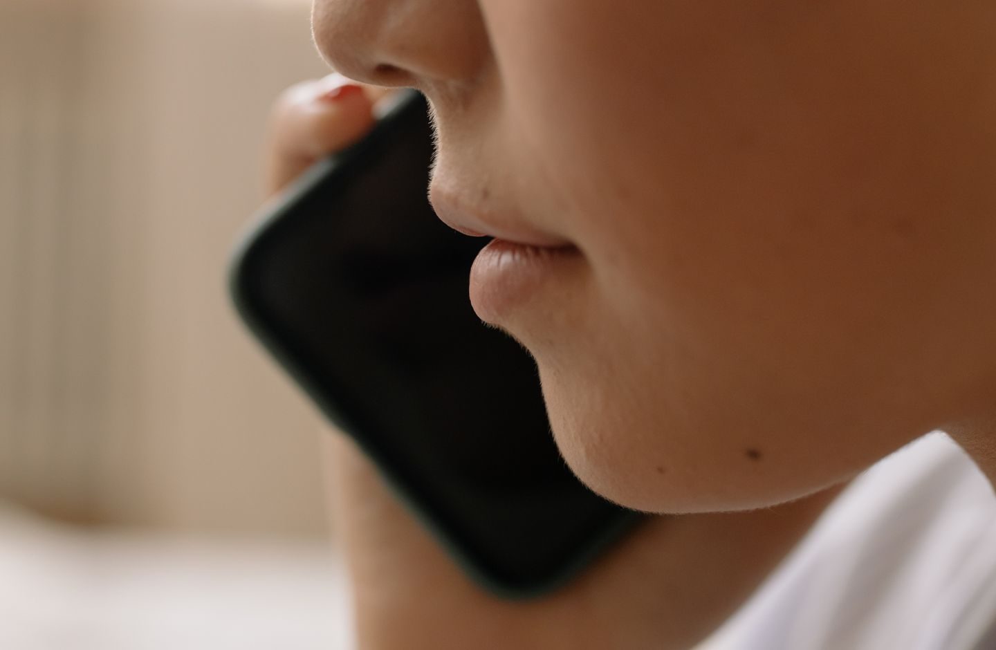 A close-up of a person talking on a smartphone.