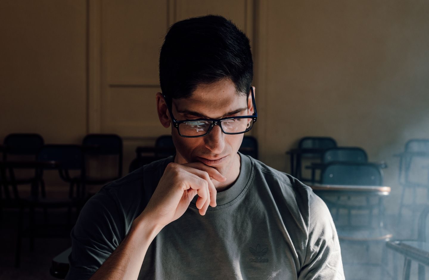 A student sitting in a classroom, deep in thought before answering.