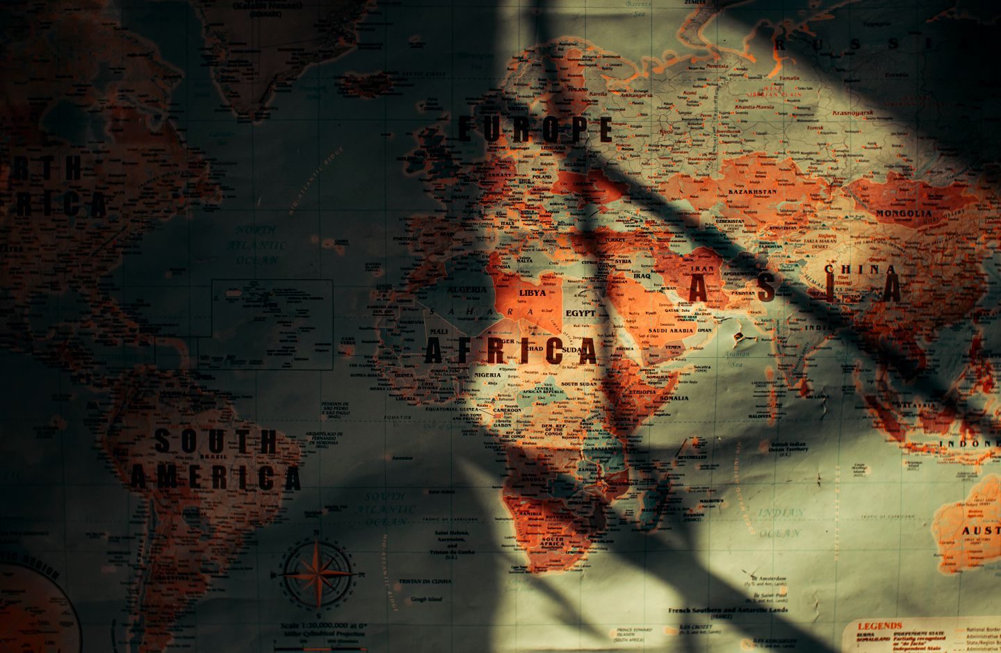 An old paper world map showing continents and oceans, seen from above.